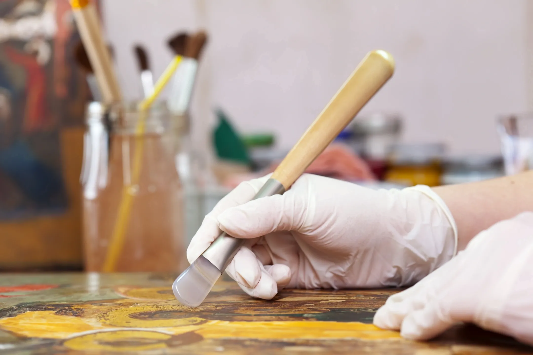 Art restorer working on a painting with a brush
